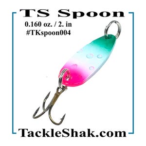 May include: A colorful fishing lure with a green, white, and pink design. The lure is 2 inches long and features a double hook. Text on the lure reads "TS Spoon" and "TackleShak.com". The lure is designed for trout, bass, and pan fish.