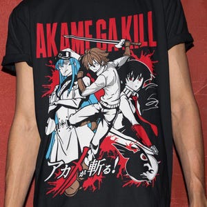 以下が含まれることがあります： 「AKAME GA KILL」の赤い文字とアニメキャラクターのグラフィックが特徴の黒いTシャツ。青、白、黒の服を着たキャラクターと日本語のテキストが含まれています。Tシャツは半袖です。