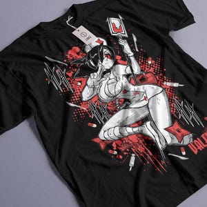 Op de afbeelding: Een zwart t-shirt met korte mouwen en een grafische print van een anime-verpleegkundige die een grote injectiespuit vasthoudt. Het ontwerp bevat rode en witte accenten, verspreide pillen, scalpels en shuriken, met een label voor maat Large.