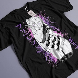 Op de afbeelding: Een zwart t-shirt met korte mouwen en een afbeelding van een elf-personage in anime-stijl met lang haar en puntige oren. Het personage draagt een gestreepte top en is omringd door paarse inktachtige spetters en Japanse karakters.