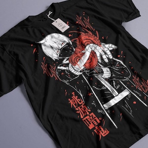 Könnte beinhalten: Schwarzes T-Shirt mit einer Illustration im Anime-Stil. Das Design zeigt eine Figur mit weißen Haaren und einer Maske, die ein rotes Herz hält. Japanischer Text ist in Rot gedruckt. Ein Etikett ist am T-Shirt befestigt.