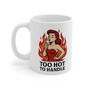 May include: White ceramic mug featuring a retro illustration of a woman in a red dress surrounded by flames. The text "TOO HOT TO HANDLE" is printed below the image. The mug has a curved handle.