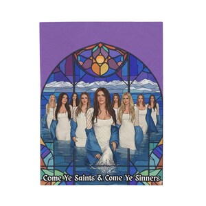 May include: A rectangular throw blanket featuring a stained-glass window design with women in white dresses and blue cloaks. The text "Come Ye Saints & Come Ye Sinners" is at the bottom. The background is purple.