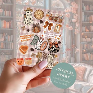 Op de afbeelding: Een rechthoekig stickervel met herfstthema-illustraties, waaronder geesten, pompoenen, cowboylaarzen, koffiekopjes en suikerappels. De tekst bevat "Kindle Girlie", "Emotional Support Kindle" en "So what's the verdict? I am an autumn."