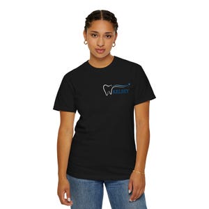 Peut inclure: T-shirt noir avec un motif dentaire blanc et bleu. Le motif comprend une dent et le nom "KELSEY" en bleu. Le t-shirt est fait d'une matière douce et convient aux tenues décontractées.