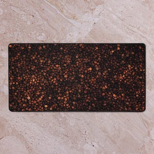 May include: A close-up of a brown and black mouse mat with a pattern of coffee beans.
