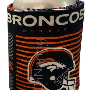 May include: A blue and orange can cooler with the words "Broncos Denver" and a Denver Broncos logo. The cooler is designed to fit a standard 12 oz can.