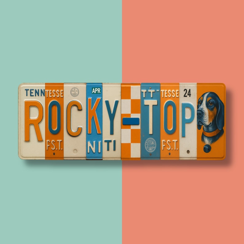 K&ouml;nnte beinhalten: Rechteckiges Metallschild mit den Worten "ROCKY TOP" in orangefarbenen und blauen Buchstaben. Das Schild hat ein Vintage-Kennzeichen-Design mit einer Hundeillustration auf der rechten Seite. Der Hintergrund ist in zwei Farben unterteilt, T&uuml;rkis und Koralle.