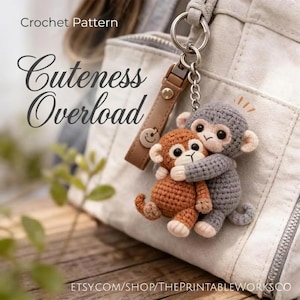 May include: A crocheted keychain featuring two hugging monkeys, one brown and one gray. The keychain is attached to a leather strap with a smiley face charm. Text on the image reads "Cuteness Overload" and "Crochet Pattern".
