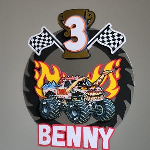 Pode incluir: Um topo de bolo de caminh&atilde;o monstro colorido com o nome "Benny" na parte inferior. O topo apresenta um caminh&atilde;o monstro com tema zumbi, chamas, bandeiras quadriculadas e o n&uacute;mero "3" em um trof&eacute;u. O fundo &eacute; uma l&acirc;mina de serra cinza.