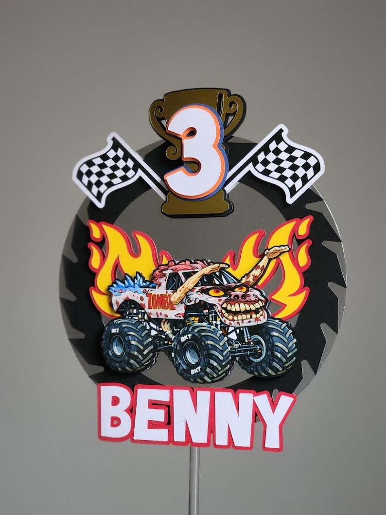 Pode incluir: Um topo de bolo de caminh&atilde;o monstro colorido com o nome "Benny" na parte inferior. O topo apresenta um caminh&atilde;o monstro com tema zumbi, chamas, bandeiras quadriculadas e o n&uacute;mero "3" em um trof&eacute;u. O fundo &eacute; uma l&acirc;mina de serra cinza.