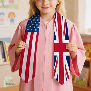 May include: A pink graduation gown with two stoles. One stole features the American flag with red and white stripes and white stars on a blue background. The other stole displays the Union Jack, the flag of the United Kingdom.
