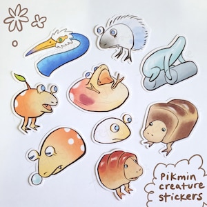 May include: A collection of colorful Pikmin creature stickers. The stickers feature various cartoon creatures in shades of orange, blue, brown, and white. The text "Pikmin creature stickers" is included in the design.