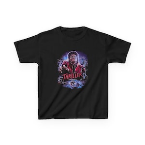 May include: Black t-shirt featuring a graphic from the music video "Thriller." The design includes a portrait of Michael Jackson in a red jacket, surrounded by zombies and the word "Thriller."