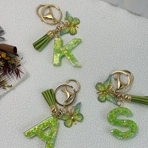 Buchstabe Schlüsselanhänger, 26 Initialen Englisch, grünes Epoxidharz einfacher Männer und Frauen Rucksack Schlüsselanhänger, Schmetterling Element, Quaste Anhänger