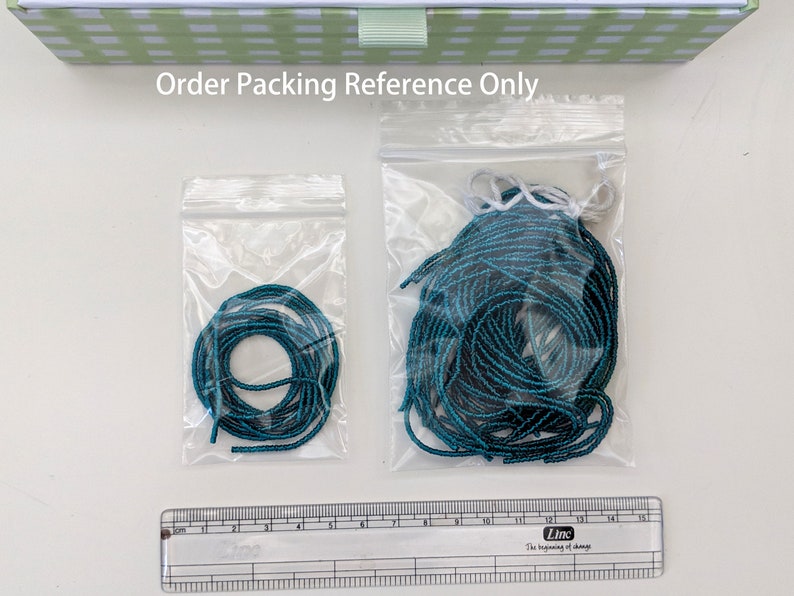 May include: Two clear plastic bags containing teal colored string. The smaller bag contains a single coil of string, while the larger bag contains a larger quantity of string.