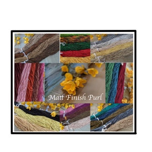 May include: A collage of various colors of Matt Finish Purl yarn. The yarn is arranged in bundles and is displayed against a wooden background. The yarn is available in a variety of colors, including red, green, blue, yellow, and brown.