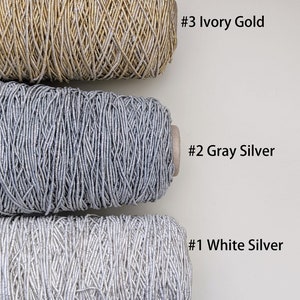 May include: Three spools of metallic thread, one ivory gold, one gray silver, and one white silver. The spools are labeled #3 Ivory Gold, #2 Gray Silver, and #1 White Silver.