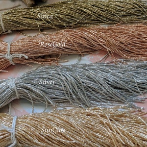 May include: Four spools of metallic thread in different colors: Silica, Rose Gold, Silver, and SunGlow.