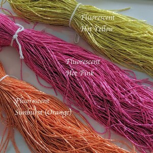 May include: Three spools of fluorescent thread in hot pink, hot yellow, and sunburst orange.