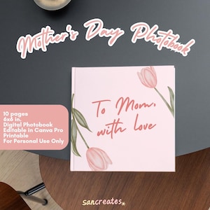 以下が含まれることがあります： ピンクのデジタルフォトブックで、花柄のデザインと「To Mom, with love」の文字が書かれています。表紙にはピンクのチューリップと緑の葉が描かれています。フォトブックは15.24 x 15.24 cmで、10ページあります。Canva Proで編集可能で、個人使用のみ印刷可能です。