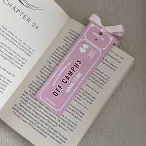 May include: A pink bookmark with the text "OFF CAMPUS BOOK CLUB" and "ADMIT ONE" is placed in an open book. The bookmark has a pink ribbon tied at the top. The book is open to Chapter 24.