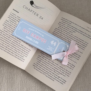 May include: Open book with a light blue bookmark that reads "OFF CAMPUS BOOK CLUB" in pink text. A pink ribbon is attached to the bookmark. The book is open to Chapter 24.