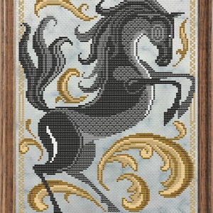 Könnte beinhalten: Ein gerahmtes Kreuzstich-Stickbild, das ein auf den Hinterbeinen stehendes schwarzes Pferd vor einem hellblauen, gesprenkelten Hintergrund zeigt. Das Design enthält goldfarbene, geschwungene Dekorelemente und einen Goldrand in einem Holzrahmen.