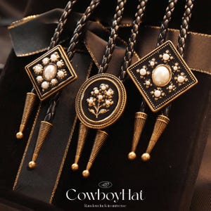 May include: Three bolo ties with black leather cords and ornate gold-toned metalwork. The bolo tie pendants feature pearl accents and floral or geometric designs. The image includes the text "Cowboyl hat" and "Random luck in universe".