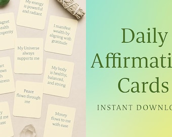 May include: A selection of Daily Affirmation Cards with positive affirmations. The cards are beige with black text, alongside a sage bundle, a clear crystal, and a green stone. The words "Daily Affirmation Cards" are displayed in green.