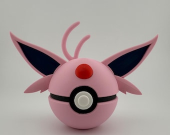 Op de afbeelding: Een roze en zwart bolvormig object met vleugelachtige aanhangsels en een rode knop bovenop. Het object heeft een witte knop in het midden en is waarschijnlijk een decoratief item of speelgoed.
