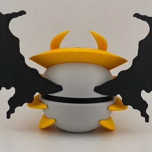 May include: A whimsical, stylized creature with a rounded, gray body, yellow accents, and large, black, wing-like appendages. The creature has a yellow hat and horns. The design is reminiscent of a cartoon character or a fantasy creature.