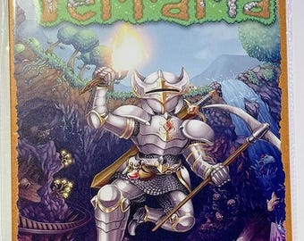 Op de afbeelding: Metalen bord met het woord "Terraria" in een pixelachtige lettertype. Het toont een ridder in zilveren harnas met een brandende fakkel en een speer. De achtergrond toont een fantasielandschap met bergen en een grot.