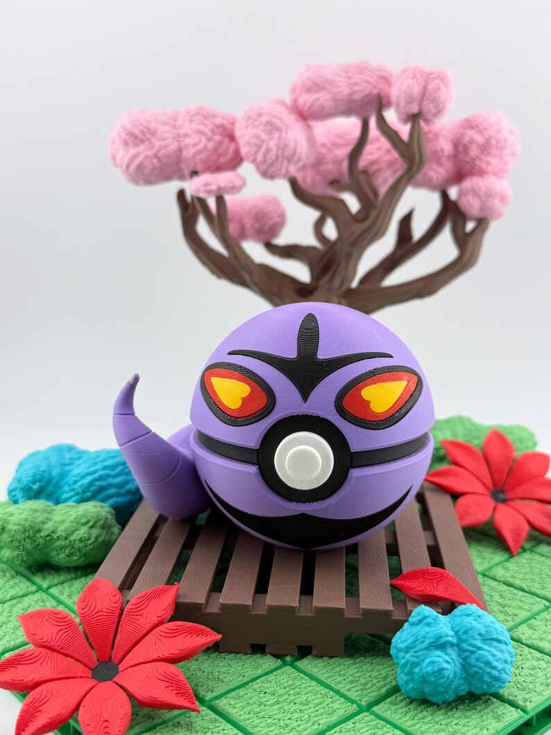 May include: A purple, spherical character with black accents, yellow and red eyes, and a curved antenna, resting on a brown wooden bridge. The scene includes red flowers, blue and green textured elements, and a pink-flowered tree.