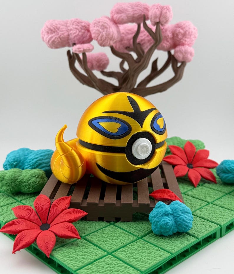 May include: A golden, spherical character with blue and black accents, resting on a brown platform. The character has a flame-like tail. The scene includes red and blue floral elements, green foliage, and a pink tree.