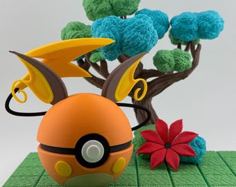 May include: An orange and black character figure with yellow accents, resembling a stylized ball, sits on a green platform. Behind it is a miniature tree with blue and green textured foliage and a red flower.