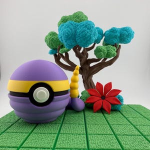 May include: A purple and yellow ball-shaped object with a white circle, resembling a cartoon character. A brown tree with green and blue foliage, a red flower, and a yellow and purple object are also present on a green surface.