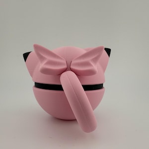 K&ouml;nnte beinhalten: Eine rosa 3D-gedruckte Skulptur einer Zeichentrickfigur mit gro&szlig;en Ohren und einem Schwanz. Die Skulptur hat schwarze Akzente und ist vor einem wei&szlig;en Hintergrund platziert. Der K&ouml;rper der Figur ist kugelf&ouml;rmig und der Schwanz zylindrisch.