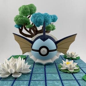 May include: A detailed figurine of a blue and white creature with tan wings, set on a blue tiled base with white lotus flowers and a miniature tree with green and blue foliage. The figurine has a black stripe.