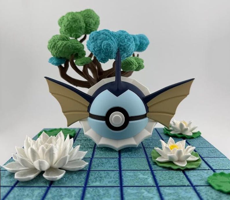 May include: A detailed figurine of a blue and white creature with tan wings, set on a blue tiled base with white lotus flowers and a miniature tree with green and blue foliage. The figurine has a black stripe.