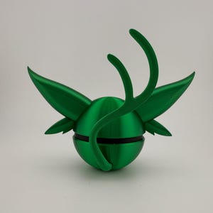 May include: A vibrant green, 3D-printed decorative object. The design features a spherical base with wing-like structures and curved, antler-like elements extending upwards. A black band encircles the sphere, adding contrast. The object is set against a plain white background.
