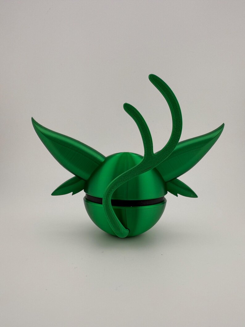 May include: A vibrant green, 3D-printed decorative object. The design features a spherical base with wing-like structures and curved, antler-like elements extending upwards. A black band encircles the sphere, adding contrast. The object is set against a plain white background.