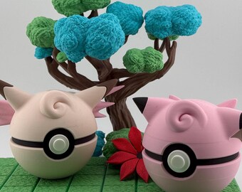 Może przedstawiać: Dwie różowe i białe figurki Jigglypuff z czarnymi detalami, umieszczone na zielonej platformie z miniaturowym drzewkiem z niebieskimi i zielonymi liśćmi. Czerwony kwiat znajduje się między figurkami. Tło jest jednolicie białe.