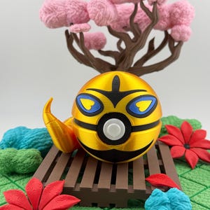 May include: A golden, spherical decorative object with black and blue accents, resembling a stylized insect. It rests on a brown wooden platform, surrounded by red flowers, blue and green textured shapes, and a pink tree.