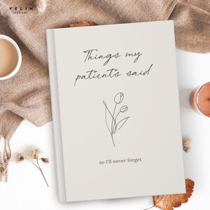 May include: A light beige hardcover journal with the black text Things my patients said and so I'll never forget printed on the front cover. A simple black line drawing of two tulips is centered between the two lines of text on the cover.