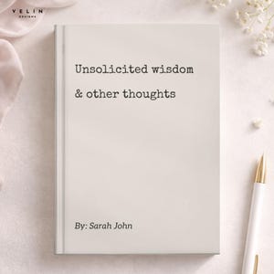 May include: A hardcover book with a light beige cover featuring the black printed text Unsolicited wisdom & other thoughts and By: Sarah John. The book is positioned vertically with a white pen placed to the right side of the cover.