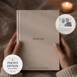 May include: A light beige hardcover journal with the text DEAR DAD centered on the front cover and the text In loving memory of James Harper at the bottom. A circular inset shows a black and white photograph of two men with a printed message.