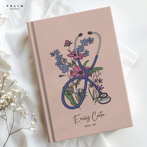 May include: A dusty rose hardcover notebook featuring a central illustration of a blue stethoscope intertwined with colourful pink and blue wildflowers. The name Emily Carter and the professional title MSN, RN are printed in black text below the graphic.