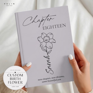 May include: A light purple hardcover journal featuring the text Chapter EIGHTEEN, a line art illustration of a daffodil, the name Sarah in script, and the phrase new chapter, new dreams, same beautiful you printed in black ink on the front cover.