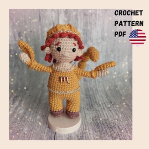 May include: A handmade crochet doll in a mustard yellow outfit, representing the Scorpio zodiac sign. The doll has red hair and a gold trim, with the Scorpio symbol on the chest. The image includes the text "CROCHET PATTERN PDF" and the American flag.
